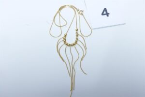 1 collier en or 750/1000 motif central à décor de petites boules et chaînette en pampille (L38cm). PB 5,6g