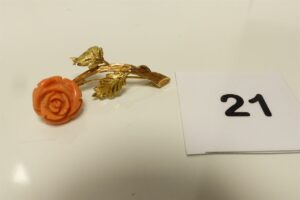 1 broche en or 750/1000 18K à décor d'une rose en corail (cabossée,L4cm). PB 6,9g