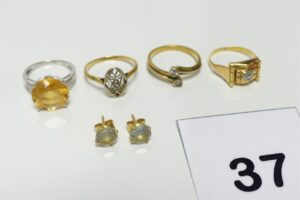 4 bagues (1 Toi et moi ornée de 2 petits diamants Td53)(1 bicolore ornée de petits diamants Td54)(1 ornée d'une petite pierre blanche Td50)(1 réhaussée d'une grosse pierre jaune épaulée de petits diamants Td49) et 2 boucles ornées d'une pierre. Le tout en or 750/1000 18K. PB 13,4g
