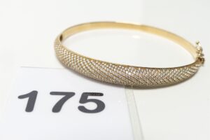1 Bracelet rigide articulée en or 750/1000 18k, motif central orné d'un pavage de petites pierres (diamètre 5/6cm). PB 8,3g