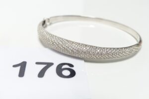 1 Bracelet rigide articulé ouvrant en or 750/1000 18k, orné d'un pavage de petites pierres (diamètre 5/6cm). PB 8,6g