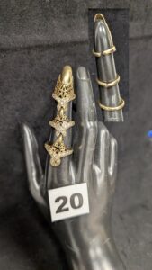 1 Bague articulée habillant tout le doigt, ongle inclus, composée de trois anneaux (TD 54 pour la plus basse, les autres réglables), et ornée de pierres blanches, en or 750/1000 18k. PB 12,4g