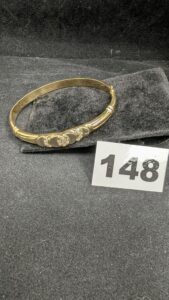 1 Bracelet rigide ouvrant orné de pierres blanches, en or 750/1000 18k. PB 16,17g