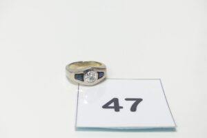 1 bague en or 750/1000 18k centré d'un diamant avec inclusion d'environ 0,60 cts et de 2 petites pierres bleues (Td52). PB 9,4g