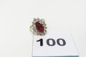 1 Bague en or 750/1000 18k, centrée d'une pierre couleur grenat entourée de petites pierres blanches (td54). PB 5,6g