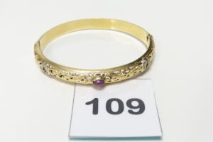 1 Bracelet rigide ouvrant en or 750/1000 18k, motif central à décor floral orné de quelques petites pierres (2 chatons vides, diamètre 5,5/6cm). PB 20g