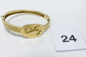 1 Bracelet rigide et ouvrant en or 750/1000 motif central à décor d'un scorpion gravé sur plaque (Diamètre 6,5cm). PB 22,1g